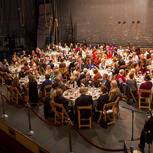 A crowd of people at an event dinner. Links to What to Give